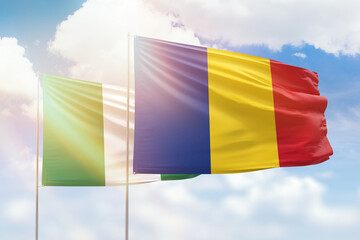 Sunny blue sky and flags of romania and nigeria
