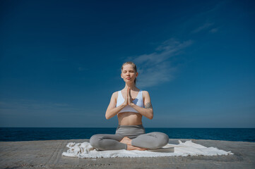 Fototapeta na wymiar Yoga practice and meditation in nature. Woman practicing near Black sea.