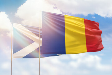 Sunny blue sky and flags of romania and scotland