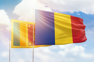 Sunny blue sky and flags of romania and sri lanka