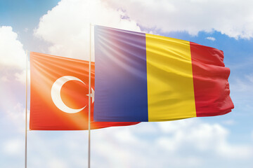 Sunny blue sky and flags of romania and turkey