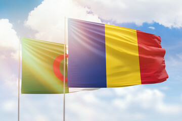 Sunny blue sky and flags of romania and algeria