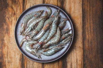Raw seafood. Fresh shrimps prawns on gray plate. Wooden backround.