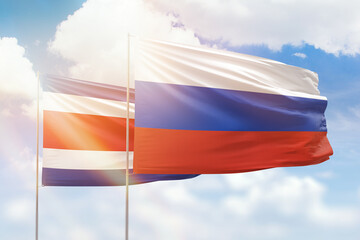 Sunny blue sky and flags of russia and costa rica