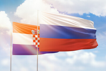 Sunny blue sky and flags of russia and croatia
