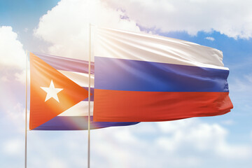 Sunny blue sky and flags of russia and cuba