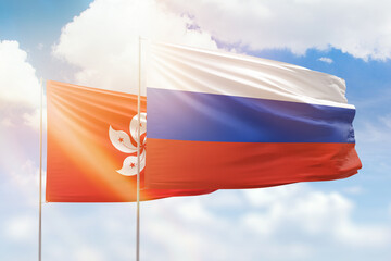 Sunny blue sky and flags of russia and hong kong