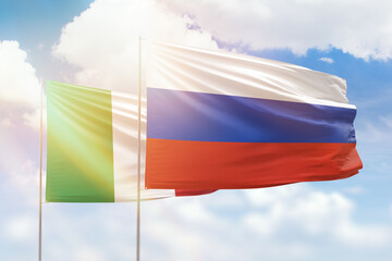Sunny blue sky and flags of russia and italy