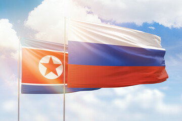 Sunny blue sky and flags of russia and north korea