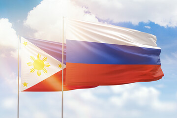 Sunny blue sky and flags of russia and philippines