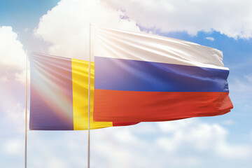 Sunny blue sky and flags of russia and romania