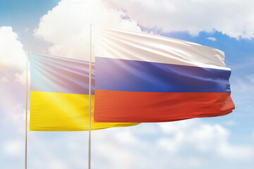 Sunny blue sky and flags of russia and ukraine