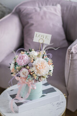 Beautiful spring flowers in box of tender peonies, roses and Gypsophila flowers. Preserved flowers for womens.