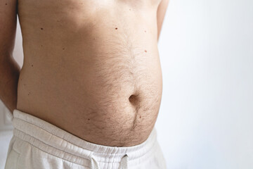 Fototapeta na wymiar Close up of fat man's belly. Perhaps the concept of abdominal pain, bloating. Health concept.