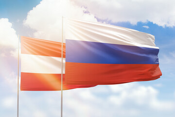 Sunny blue sky and flags of russia and austria