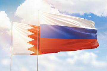 Sunny blue sky and flags of russia and bahrain