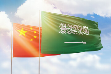 Sunny blue sky and flags of saudi arabia and china