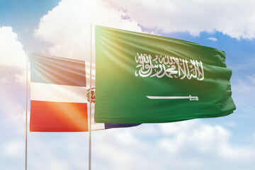 Sunny blue sky and flags of saudi arabia and dominican republic