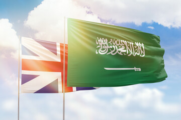 Sunny blue sky and flags of saudi arabia and great britain