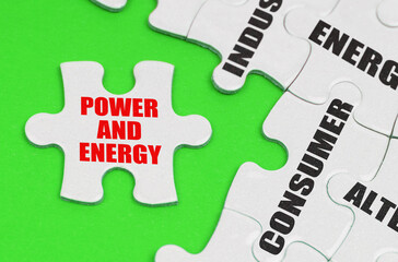 On a green surface are white puzzles with text, on a separate puzzle there is an inscription - Power And Energy