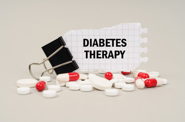 Among the tablets and capsules is a clip with paper on which is written - DIABETES THERAPY