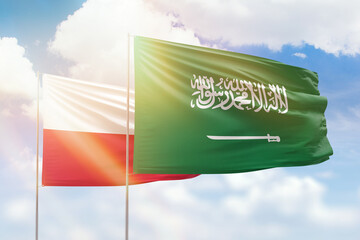 Sunny blue sky and flags of saudi arabia and poland