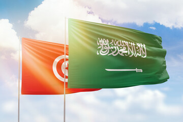 Sunny blue sky and flags of saudi arabia and tunisia