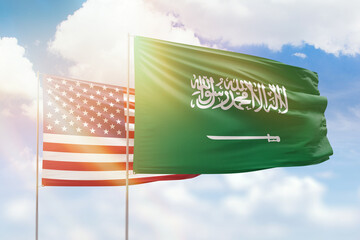 Sunny blue sky and flags of saudi arabia and usa