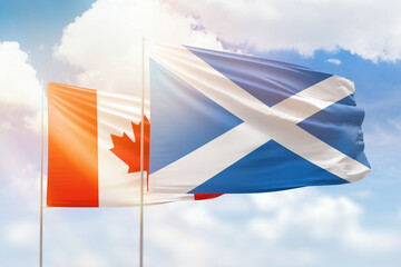 Sunny blue sky and flags of scotland and canada