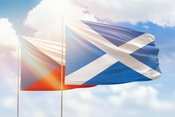 Sunny blue sky and flags of scotland and czechia