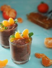 Chocolate mousse dessert with tangerines in glasses