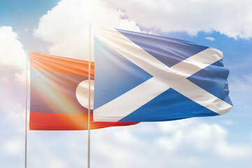 Sunny blue sky and flags of scotland and laos