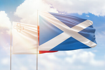 Sunny blue sky and flags of scotland and malta