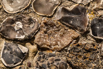 Closeup on various flint stones used in UK as a building material in architecture. Flint is the hardest of building stones, used by the Romans for castle walls and by medieval masons for churches
