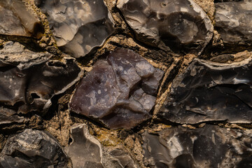 Closeup on various flint stones used in UK as a building material in architecture. Flint is the hardest of building stones, used by the Romans for castle walls and by medieval masons for churches