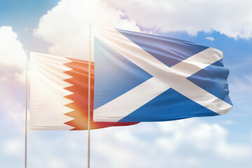 Sunny blue sky and flags of scotland and qatar