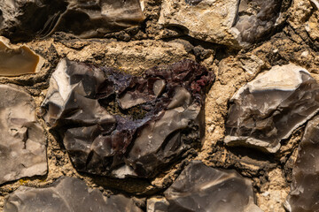 Closeup on various flint stones used in UK as a building material in architecture. Flint is the hardest of building stones, used by the Romans for castle walls and by medieval masons for churches