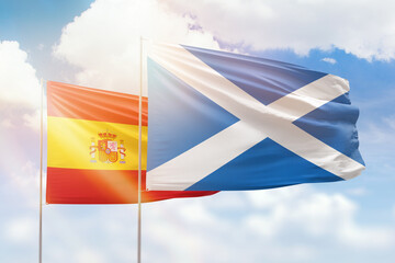 Sunny blue sky and flags of scotland and spain