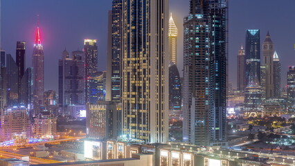 Row of the tall buildings around Sheikh Zayed Road and DIFC district aerial day to night timelapse in Dubai