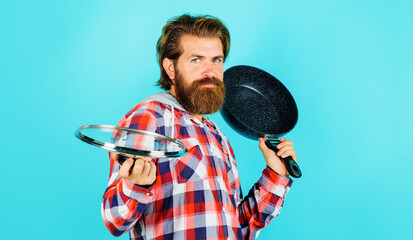 Bearded man with frypan. Male chef with frying pan and lid. Kitchenware. Cooking utensils.