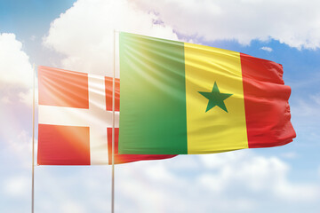 Sunny blue sky and flags of senegal and denmark