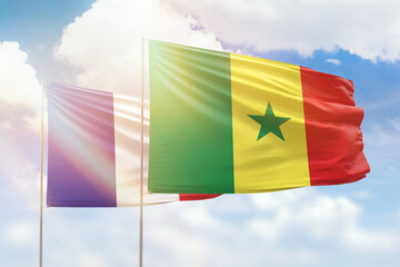 Sunny blue sky and flags of senegal and france