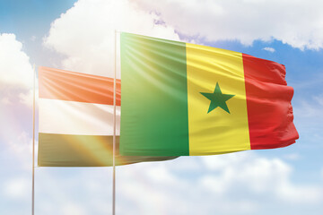 Sunny blue sky and flags of senegal and hungary