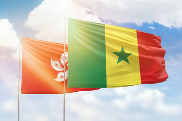 Sunny blue sky and flags of senegal and hong kong