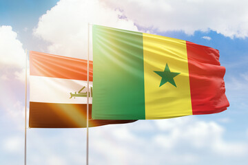 Sunny blue sky and flags of senegal and iraq