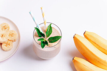 Banana smoothie with ingredients on white background. Top view