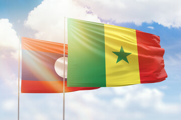 Sunny blue sky and flags of senegal and laos
