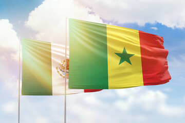 Sunny blue sky and flags of senegal and mexico