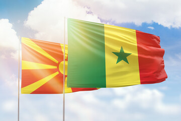 Sunny blue sky and flags of senegal and north macedonia