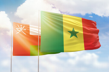 Sunny blue sky and flags of senegal and oman